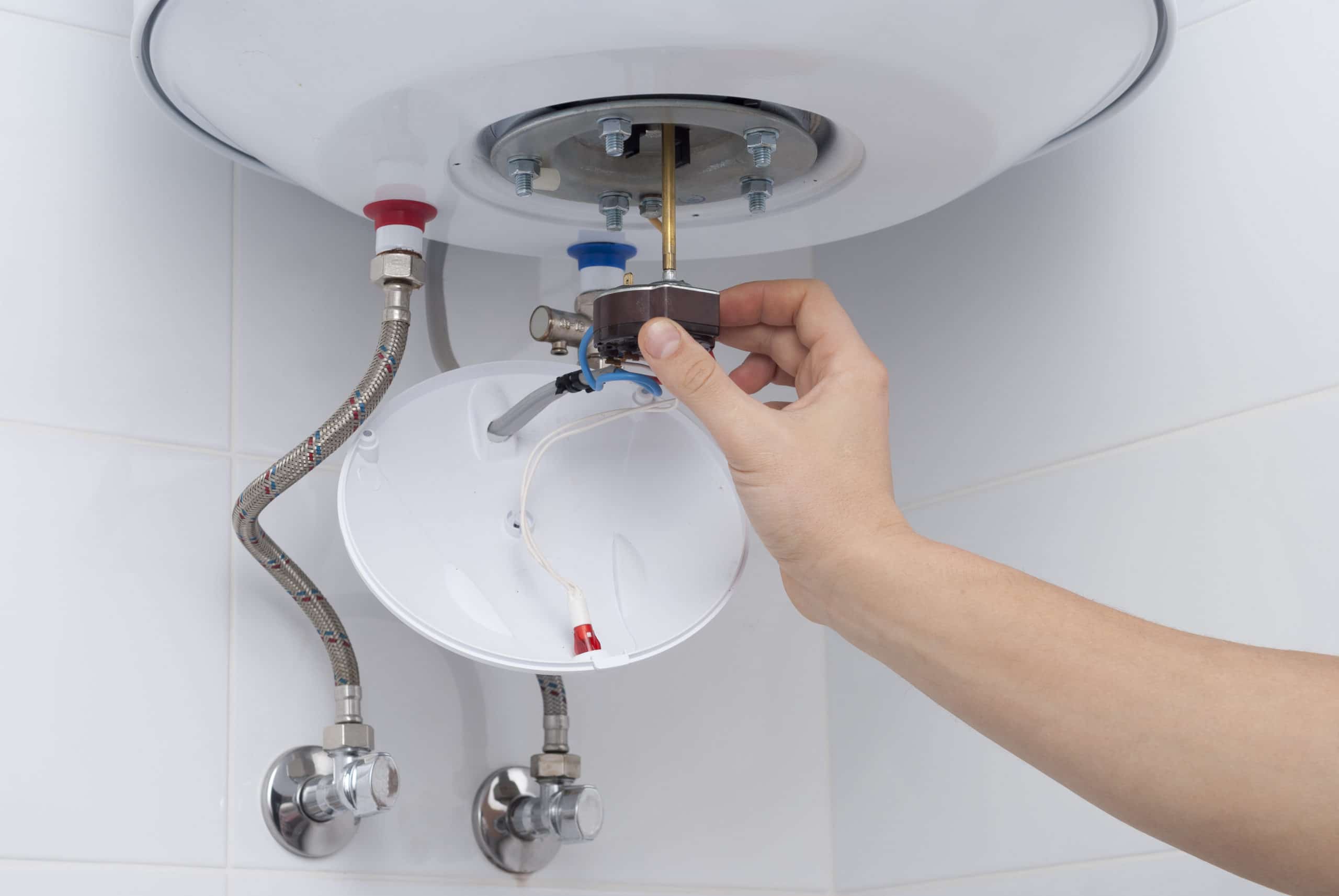 repair electric boiler master holds a thermostat from an electric boiler in his hand